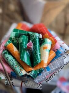 Cette photo représente une fleur de papier en forme de rose réalisée à partir de cartes météorologiques