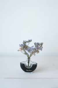 Cette photo représente une composition florale associant fleurs de papier et fleurs séchées dans les teintes violettes