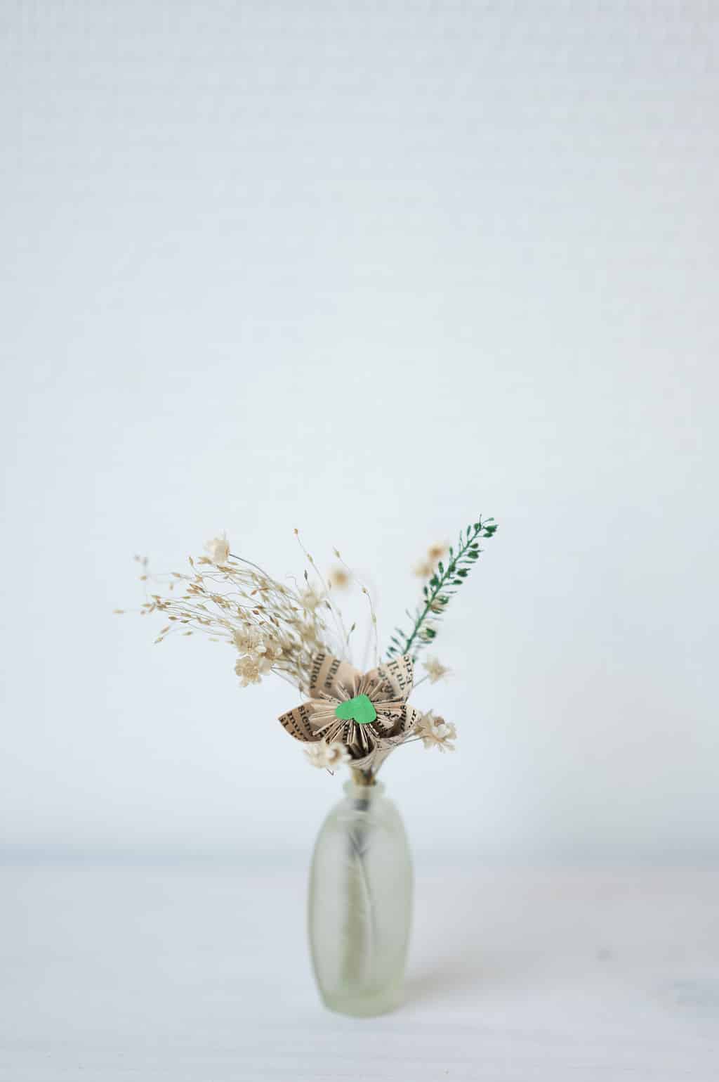 Cette photo représente une composition florale associant fleur de papier et fleurs séchées dans les tons verts
