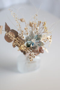 Photographie représentant une composition florale de la marque Bourgeon Bavard. Cette composition est un mélange de fleurs séchées et de fleurs en papier Upcyclé.