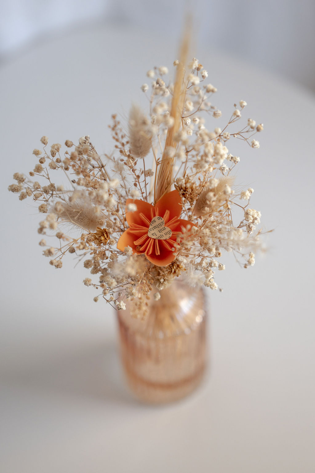 Photographie représentant une composition florale de la marque Bourgeon Bavard. Cette composition est un mélange de fleurs séchées et de fleurs en papier Upcyclé.